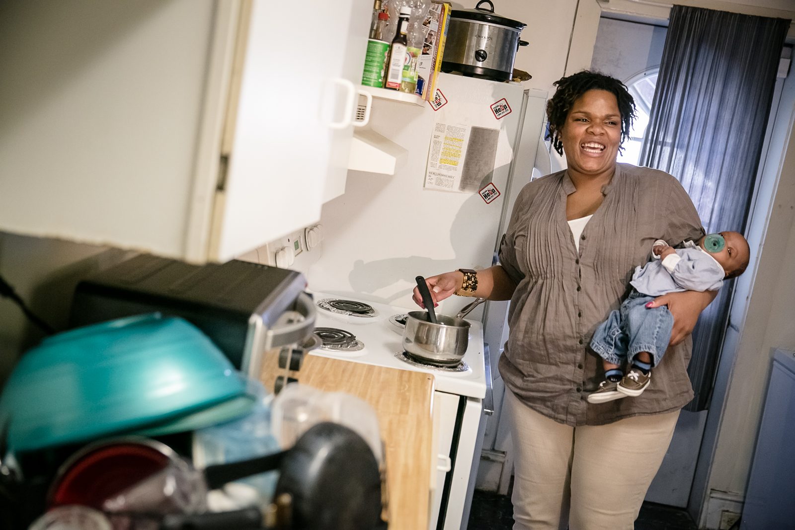 A smiling maternity home resident holds her baby.